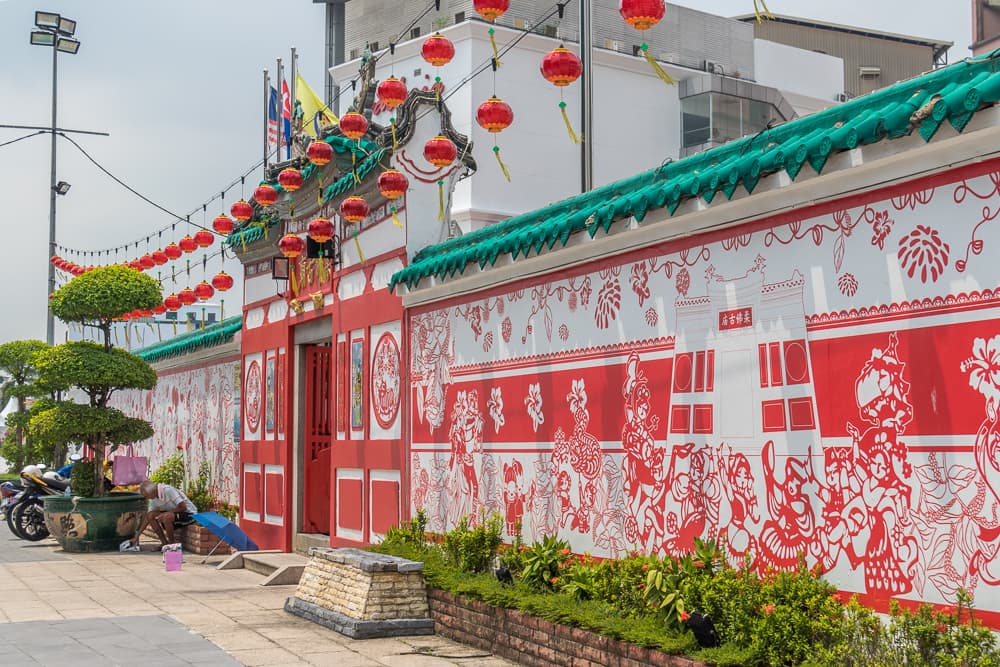 Red-and-white frontage, green tiled eaves and lanterns at Johor Ancient Temple, photographed by Graystravels in September 2019